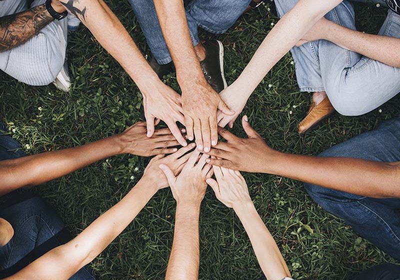 saap-800_0006_people-stacking-hands-together-park